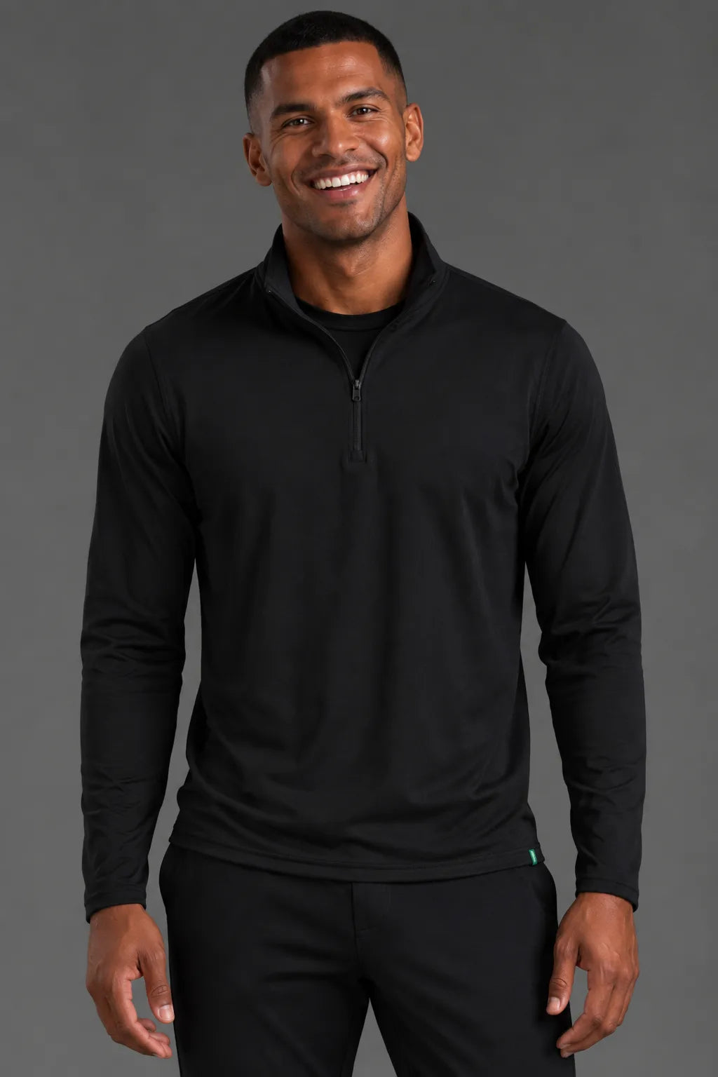 Male model smiling in the Men’s Black Quarter Zip with matching black joggers. || Black