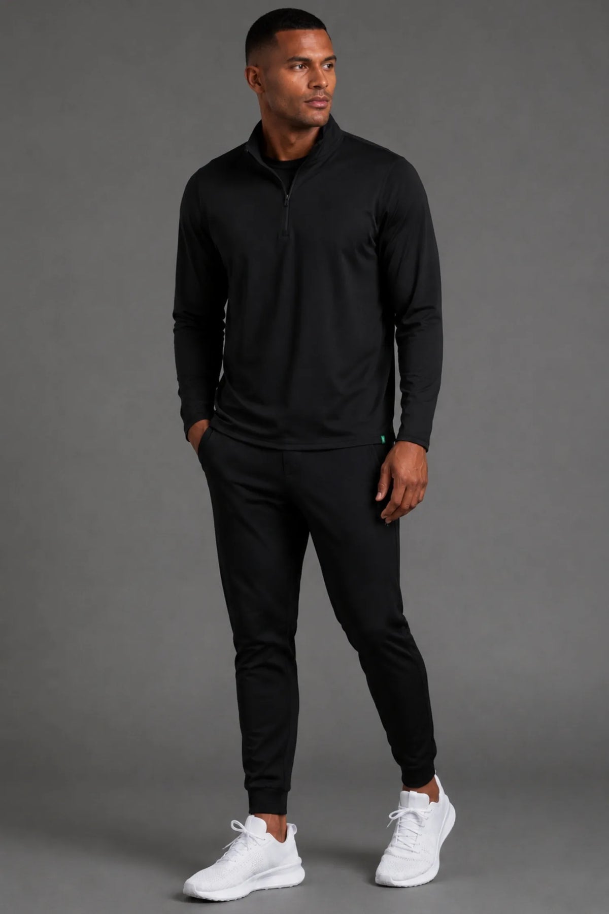 Male model wearing the Men’s Black Quarter Zip with matching black joggers.|| Black