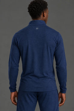Back view of male model wearing the Men’s Navy Quarter Zip, featuring the XX-XY logo below the collar. || Navy