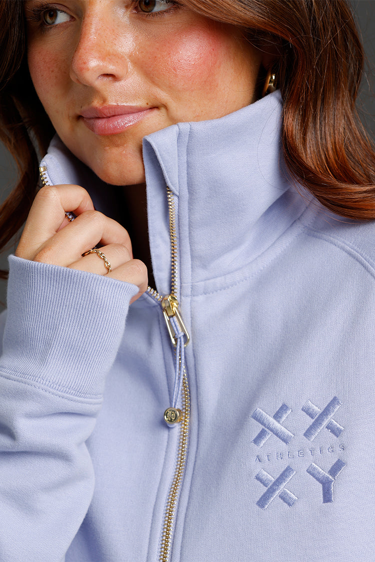 Close-up of a person wearing a Lavender jacket with a brand logo