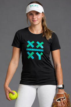 Female softball player wearing a black XX-XY Athletics graphic tee, white softball pants, black knee-high socks, and a white visor while holding a softball glove against a gray studio background. || Black
