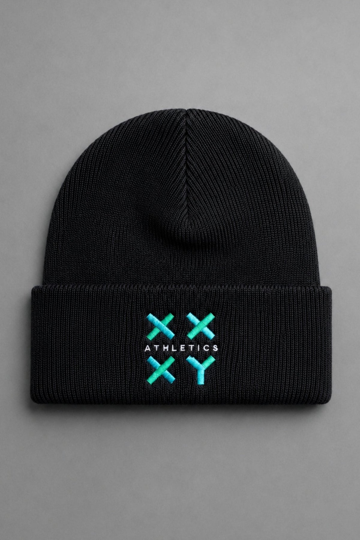 A black ribbed knit beanie hat with a folded cuff, featuring a turquoise and white embroidered logo on the front that reads 'ATHLETICS' with crossed 'X' symbols. The beanie is photographed flat against a neutral gray background.