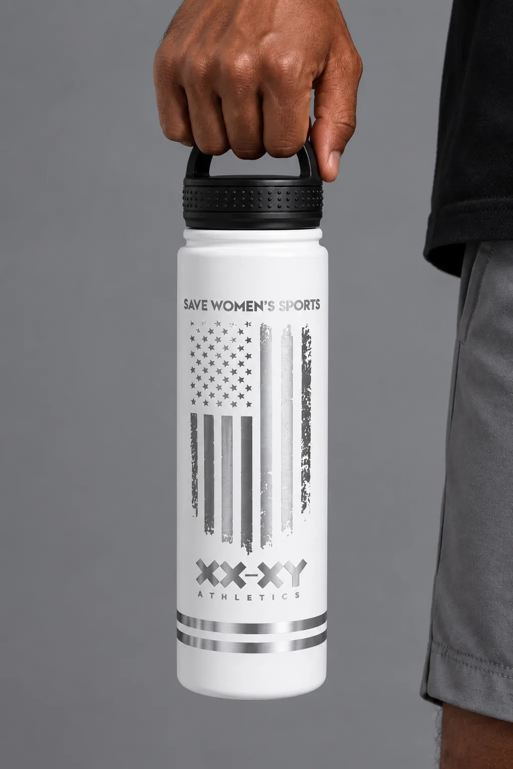 Male model holding the white XX-XY Athletics Save Women’s Sports water bottle by the lid. || White
