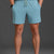 Person wearing light blue shorts and white sneakers on a gray background || Underseas