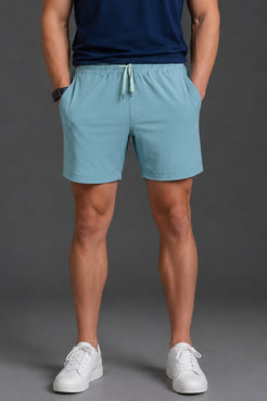 Person wearing light blue shorts and white sneakers on a gray background || Underseas
