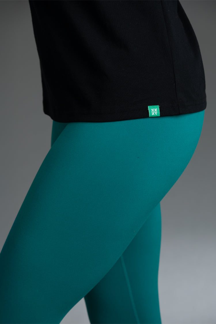Teal leggings with a black top on a gray background || Black