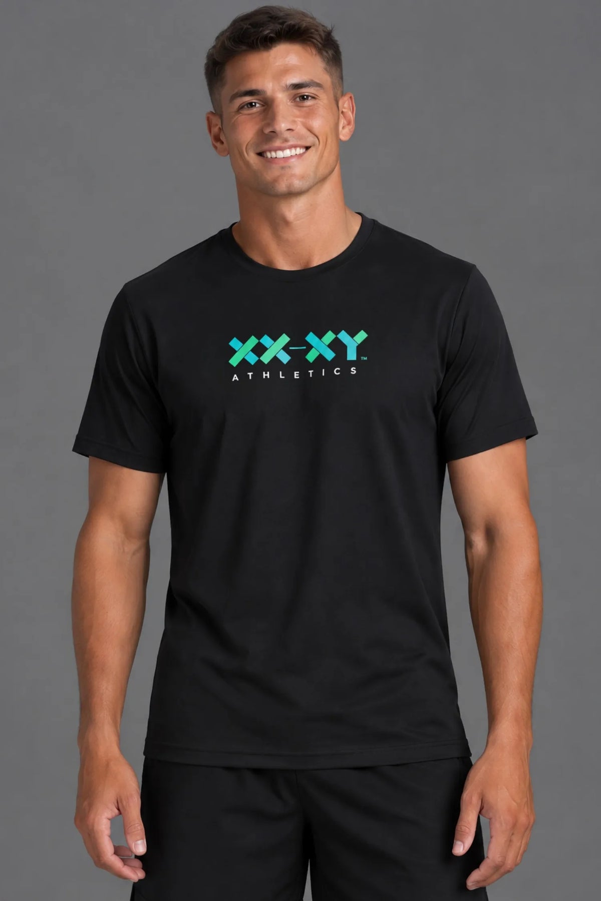Male model wearing the Men’s XX-XY Athletics Logo Tee in black with black athletic shorts. || Black
