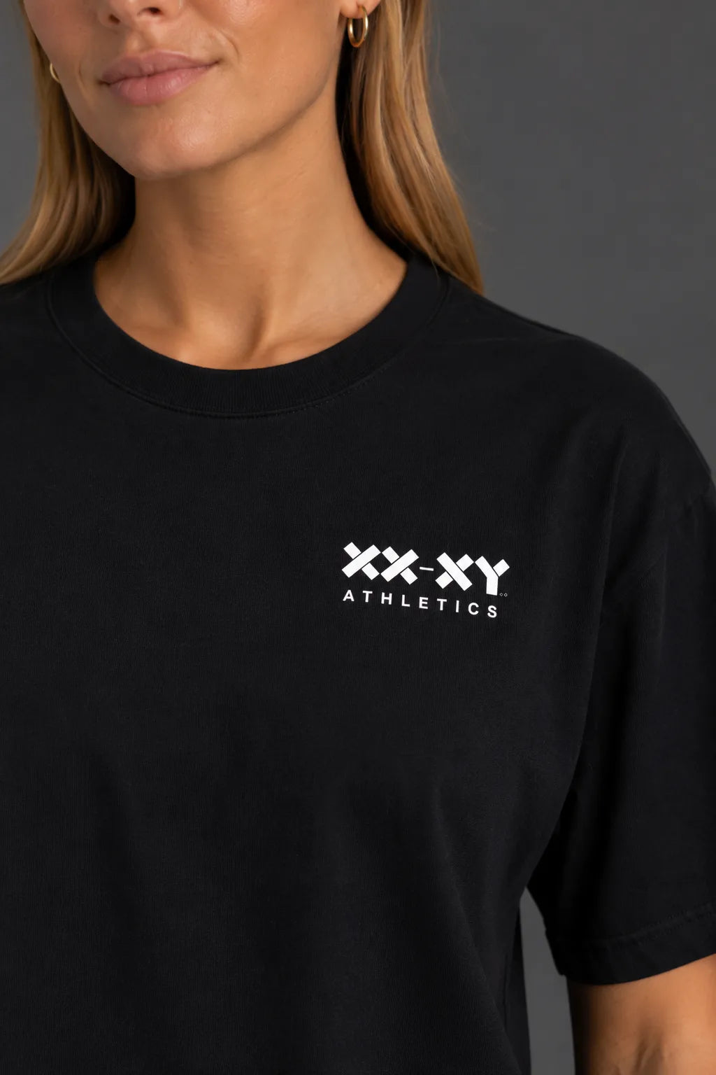 Close-up of the white XX-XY Athletics chest logo on a black boyfriend-fit tee. || Black