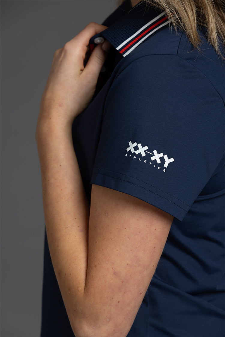 Navy blue polo shirt with a logo on the sleeve, worn by a person || Navy