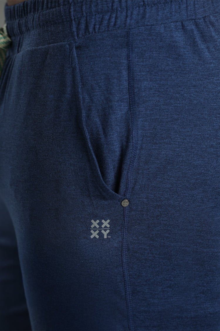 Close-up of blue pants with a small logo on the waistband. || Navy