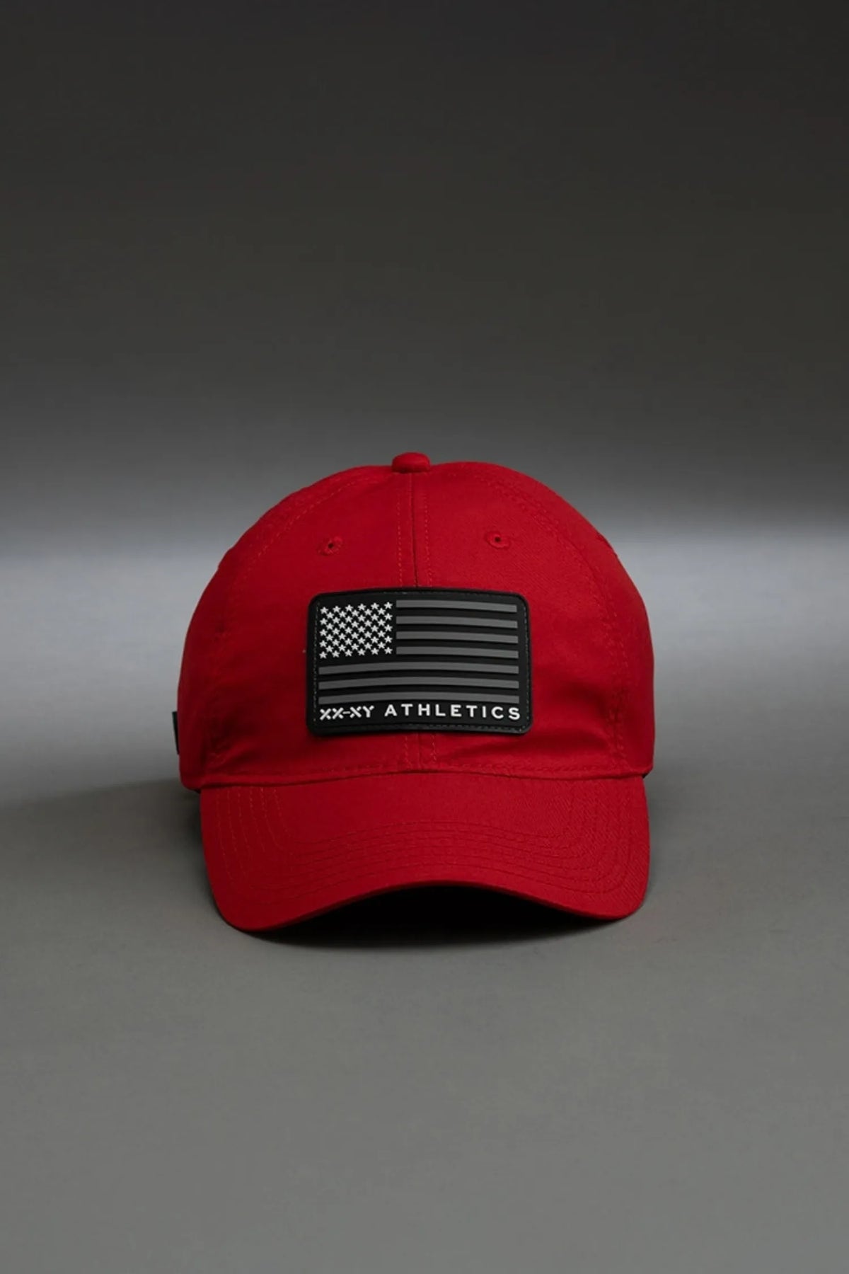 Red cap with a black patch on a gray background || red