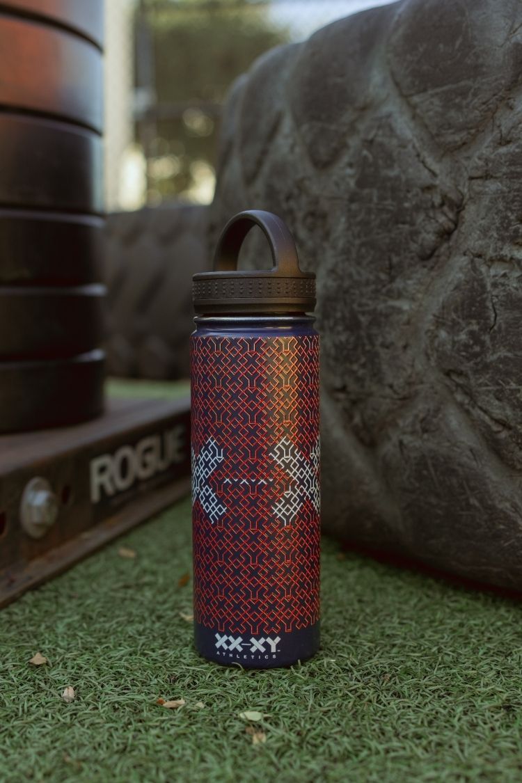 Patterned water bottle on grass with blurred gym equipment in the background || Navy Patriotic