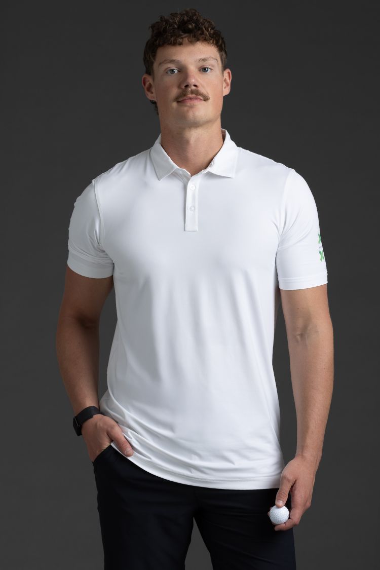 Man wearing a white polo shirt against a dark background || White