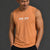 Man wearing an orange tank top with a logo on a dark background || Light Orange
