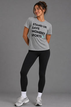 Woman wearing the gray Stand Up Save Women’s Sports tee with black leggings and sneakers || Heather Gray