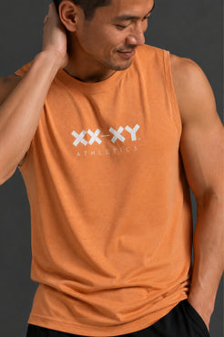 A man wearing an orange athletic tank top with a white 'XX-XY ATHLETICS' logo on the chest, photographed against a dark gray studio background. || Light Orange