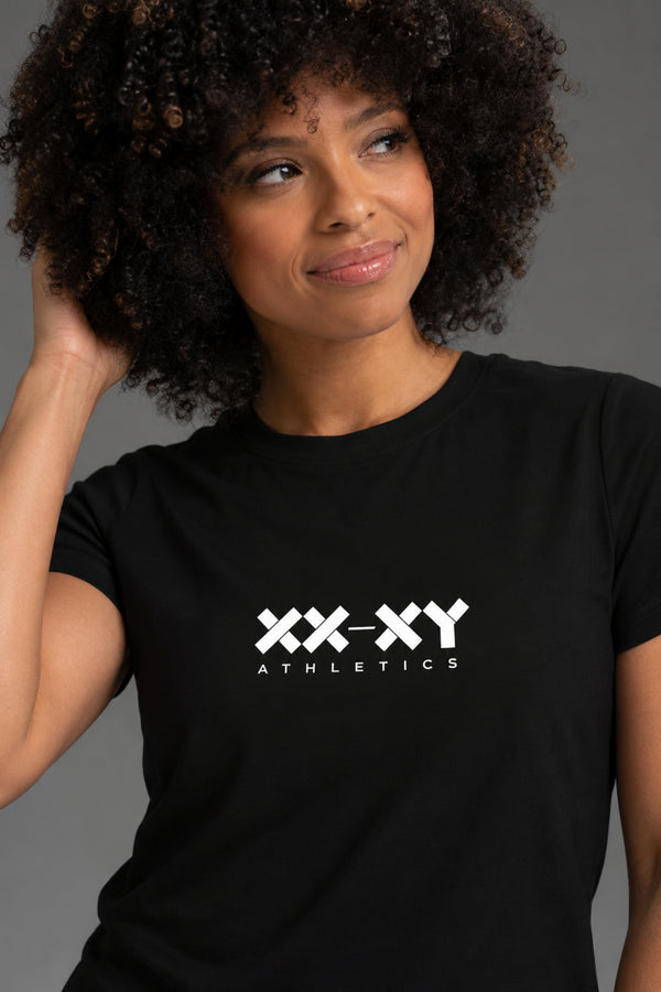 Close-up of woman wearing a black XX-XY Athletics tee, highlighting the white chest logo. || Black