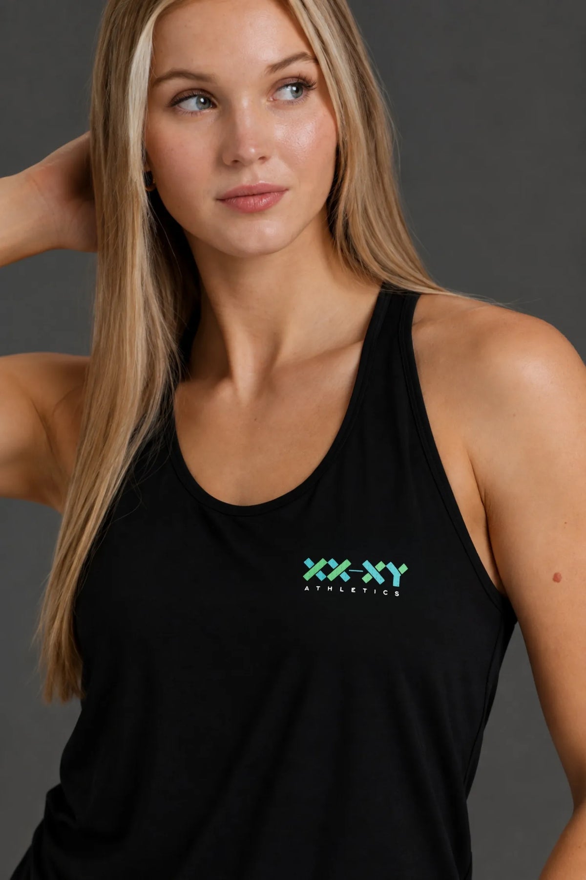 Close-up of woman wearing a black XX-XY Athletics performance tank with teal logo. || Black