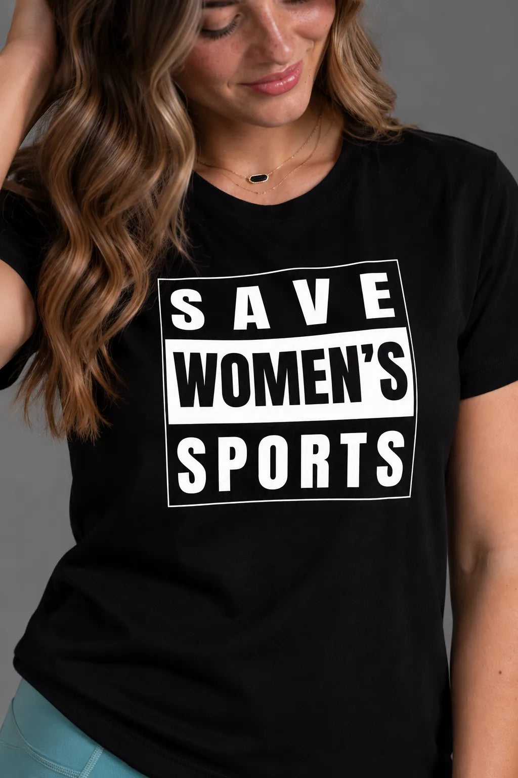 Close-up of the white Save Women’s Sports graphic on a black women’s tee. || Black
