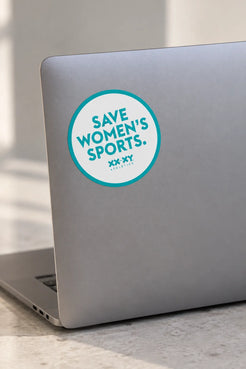 Round Save Women’s Sports XX-XY Athletics sticker on the back of a silver laptop.