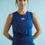 Woman wearing a blue sleeveless top with 'USA' logo against a light blue background || Navy