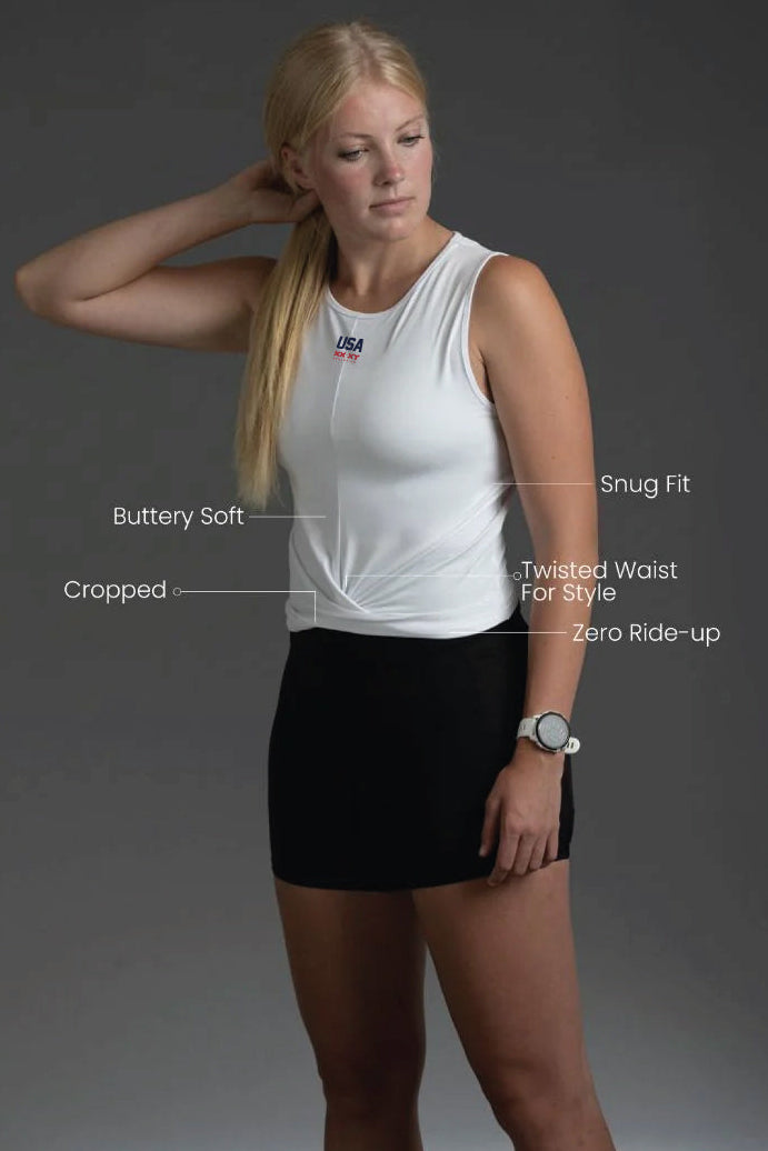 Woman wearing a white sleeveless top and black skirt with text describing features on a gray background || White