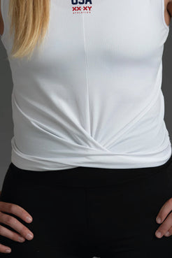 White sleeveless top with 'USA' logo on a person against a dark background || White