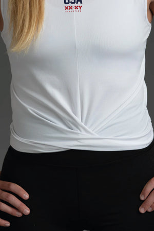 White sleeveless top with 'USA' logo on a person against a dark background || White