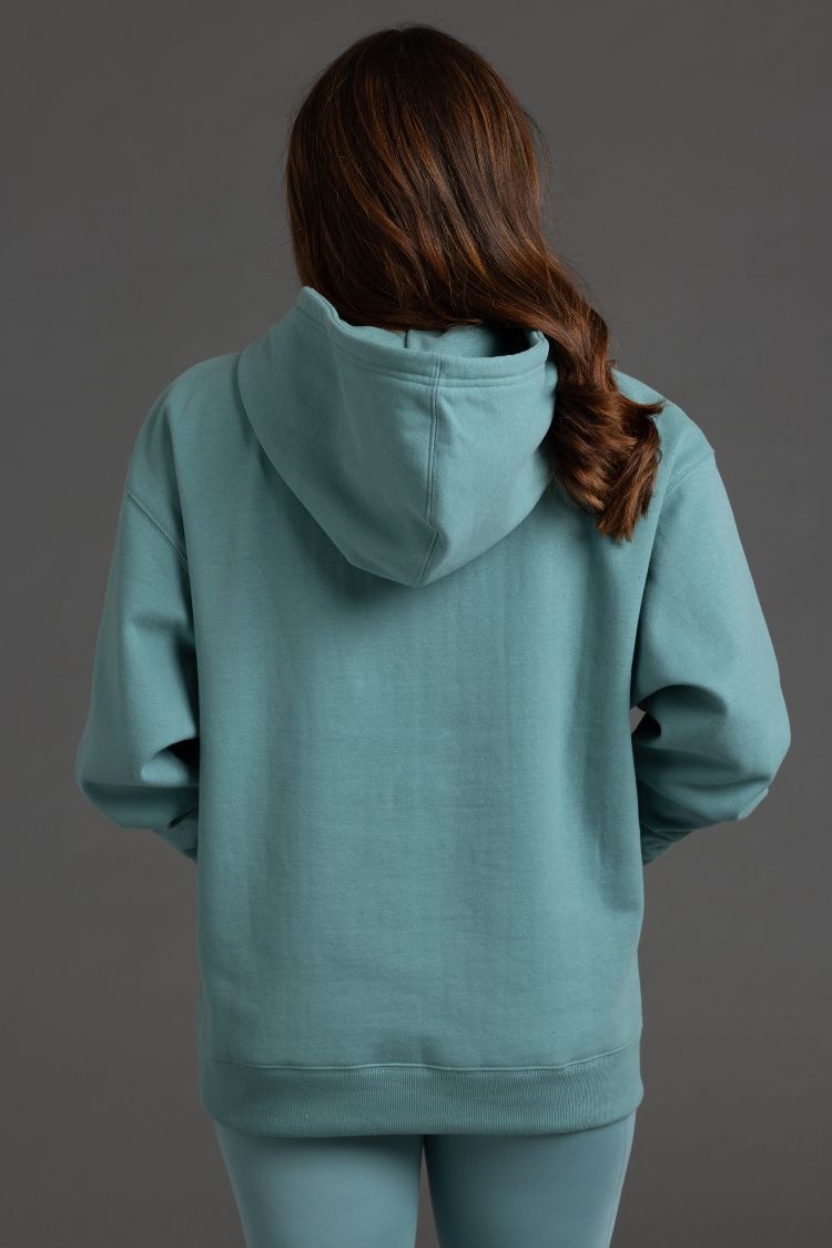 Person wearing a teal hoodie and pants on a dark gray background || Underseas