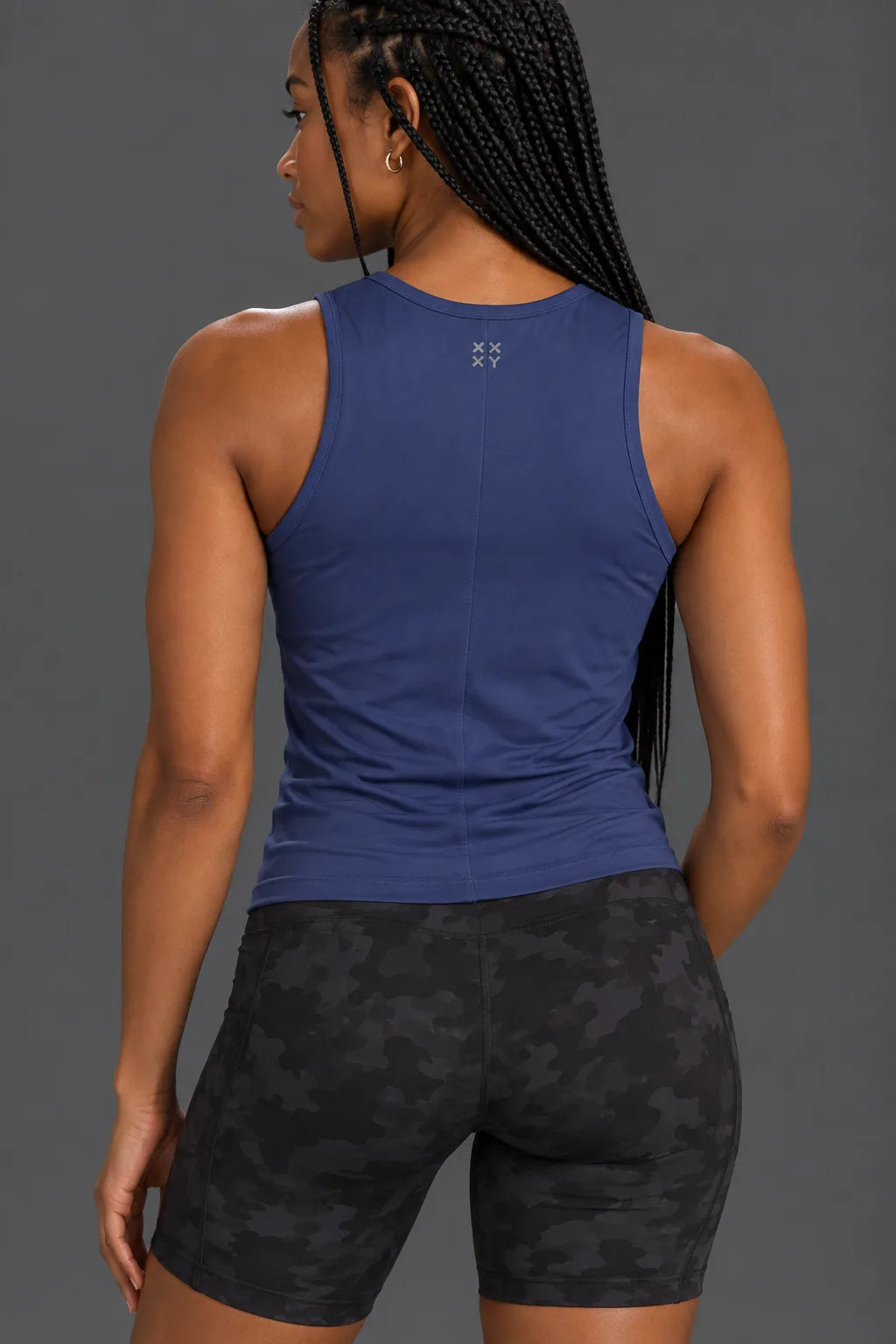 Back view of navy performance tank with XX-XY logo and black camo bike shorts. || Indigo