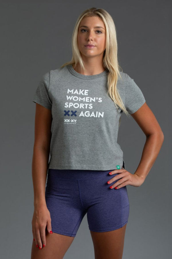 Woman wearing a gray t-shirt with 'Make Women's Sports Again' text on a gray background || Light Heather Gray
