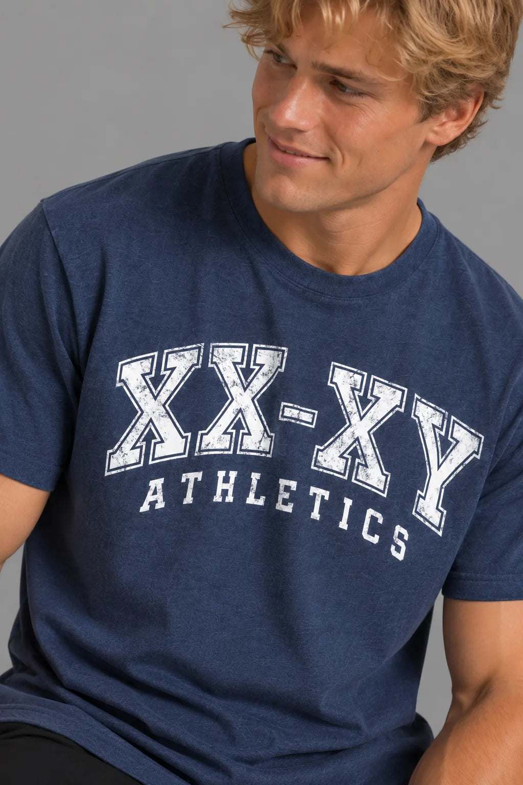 Close-up of the XX-XY Athletics Varsity Logo Tee, highlighting the distressed white varsity lettering and navy cotton fabric