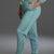 Person wearing a teal tracksuit with white sneakers on a gray background || Underseas