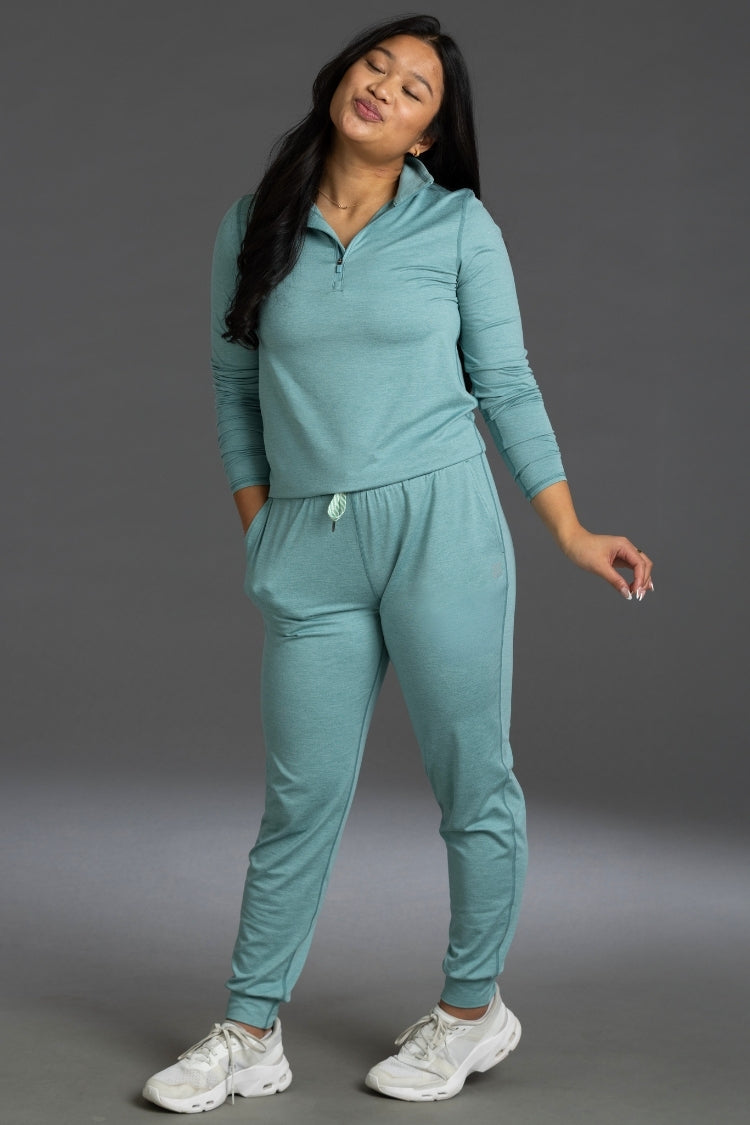 Woman wearing a teal tracksuit against a gray background || Underseas