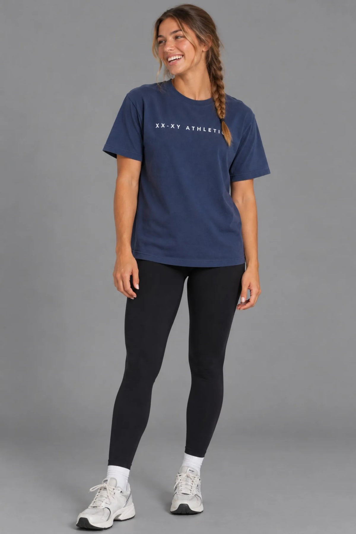 Close-up of female model wearing the XX-XY Athletics Wordmark Logo Boyfriend Tee, highlighting the white chest logo and navy cotton fabric || Navy