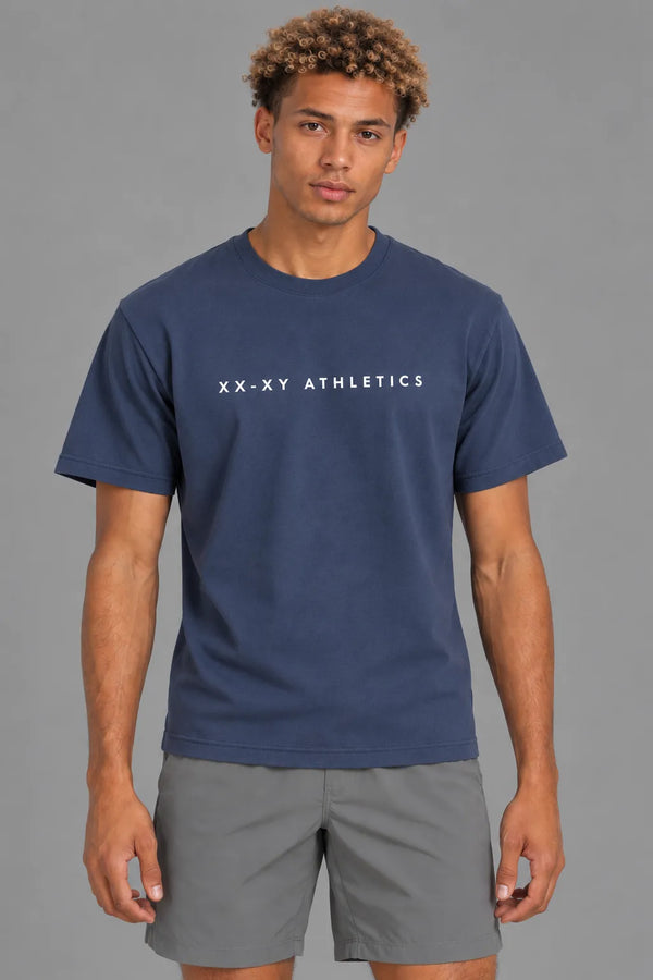 Male model facing forward in the XX-XY Athletics Wordmark Logo Tee, featuring white lettering across the chest || Navy