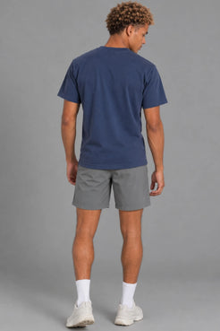 Male model showcasing the plain back of the XX-XY Athletics Wordmark Logo Tee, paired with gray shorts || Navy