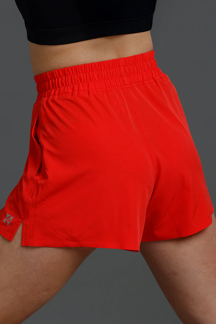 Red athletic shorts worn by a person on a gray background