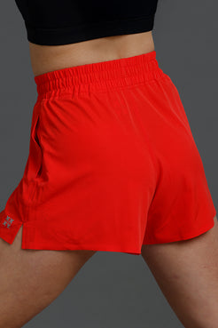 Red athletic shorts worn by a person on a gray background || Red