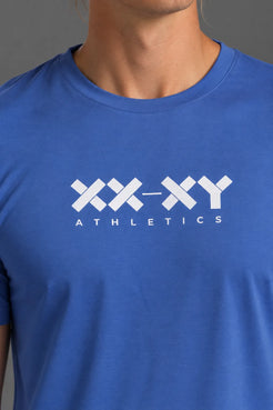 Close-up of the white XX-XY Athletics logo on the blue men’s tee. || Cobalt Blue