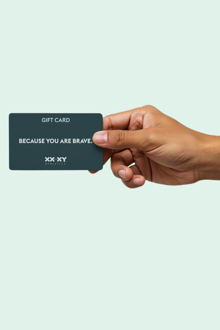 Hand holding a gift card with 'Because You Are Brave' text on a light blue background