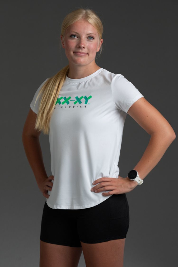 Woman wearing a white t-shirt with 'XX-XY Athletics' logo on a gray background