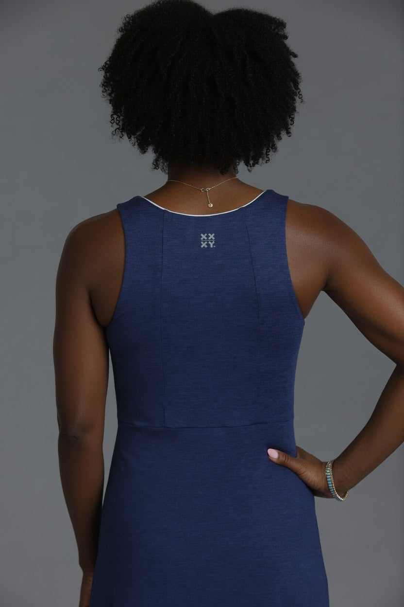 Person wearing a blue dress with a logo on a gray background || Navy
