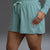 Teal athletic outfit with shorts and long-sleeve top on a gray background || Underseas