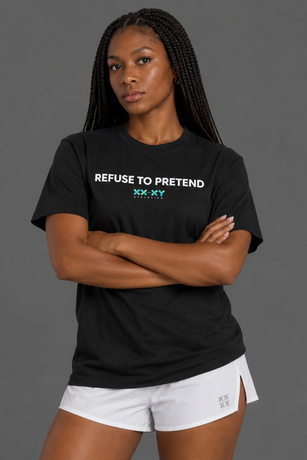 Female model wearing black XX-XY Athletics Refuse to Pretend graphic t-shirt with white athletic shorts, arms crossed against gray background. || Black