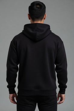 Person wearing a black hoodie from behind on a gray background  || Black
