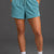 Person wearing teal shorts and white sneakers on a gray background || Underseas