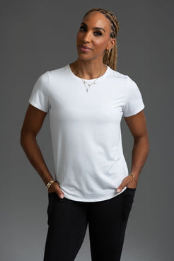 Woman wearing a white t-shirt and black pants against a gray background || White