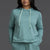 Woman wearing a teal hoodie and shorts set on a gray background || Underseas