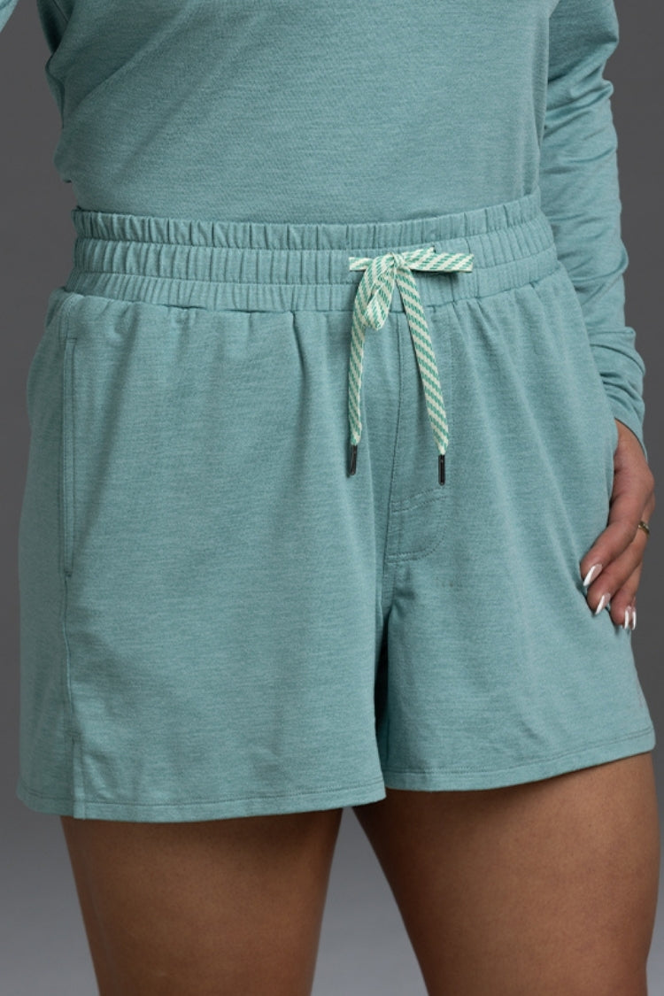 Teal shorts with a drawstring on a plain background